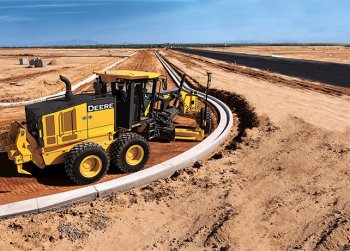A John Deere motor grader levels ground for a roadway within the wilderness