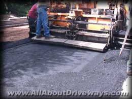 an asphalt paving machine laying a fresh asphalt driveway