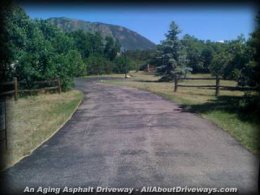 an older asphalt driveway therefore the effects of aging and oxidization from the sunlight