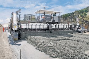 With larger slipform pavers, the spreading plough distributes the concrete throughout the entire working width